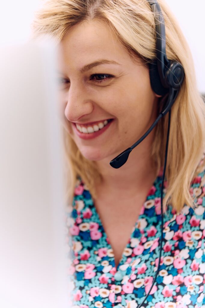 Friendly Call Center Agent Answering Incoming Calls with Headset Providing Remote Customer Service.