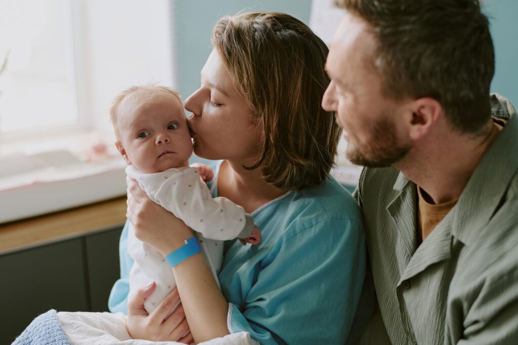 Loving Family Moment with Infant Being Kissed by Mother